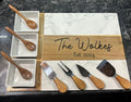 Charcuterie board with gold wood frame, three white bowls, and wooden-handled serving tools