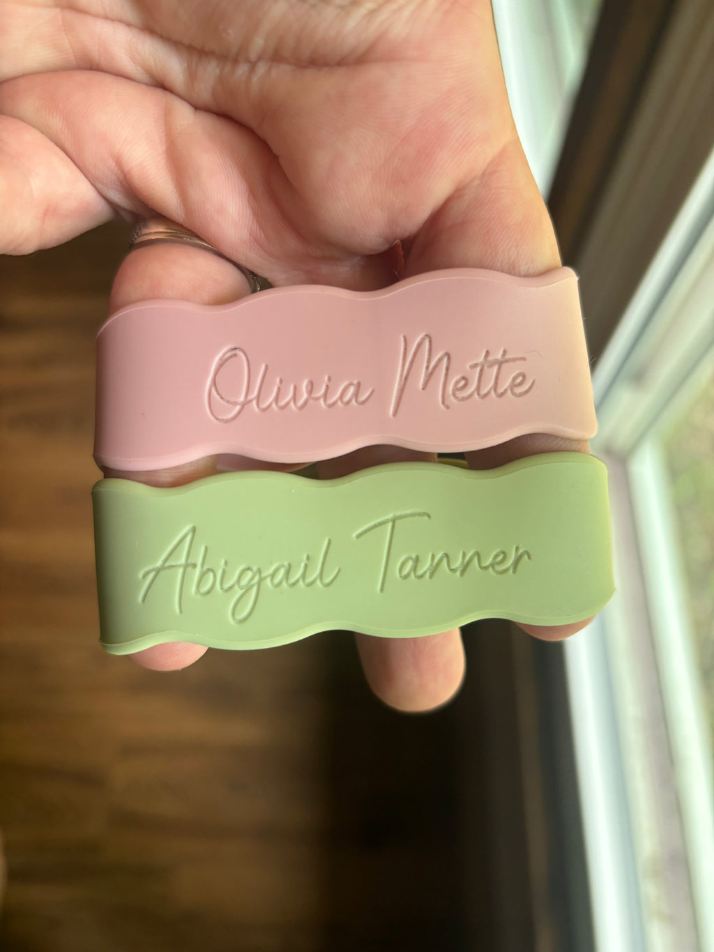 Silicone name bands in pink and green with engraved names Olivia Meitte, Abigail Tanner