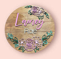 Round wooden floral baby name sign with names Lanie and Rae, colorful rose border