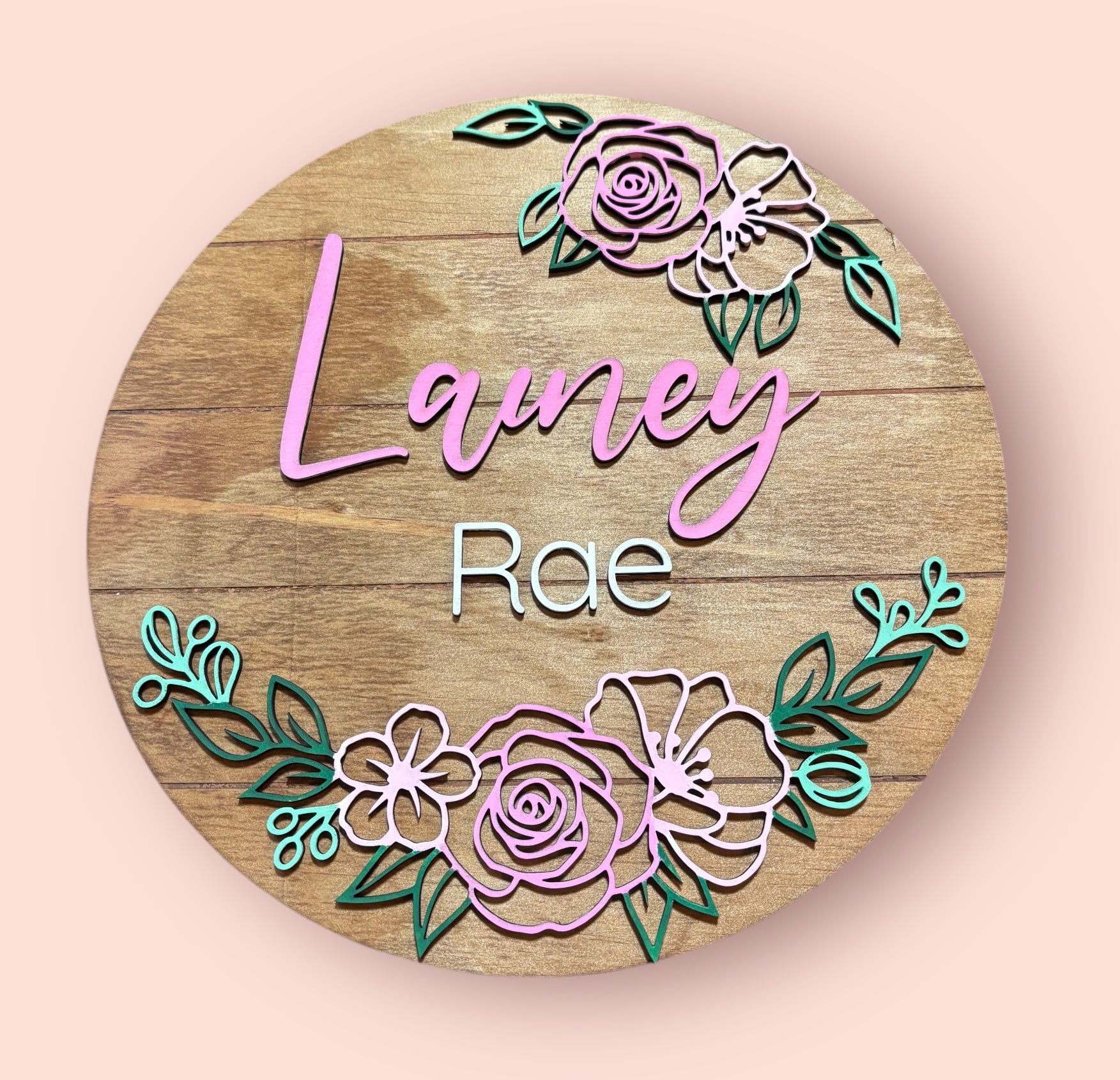 Round wooden floral baby name sign with names Lanie and Rae, colorful rose border