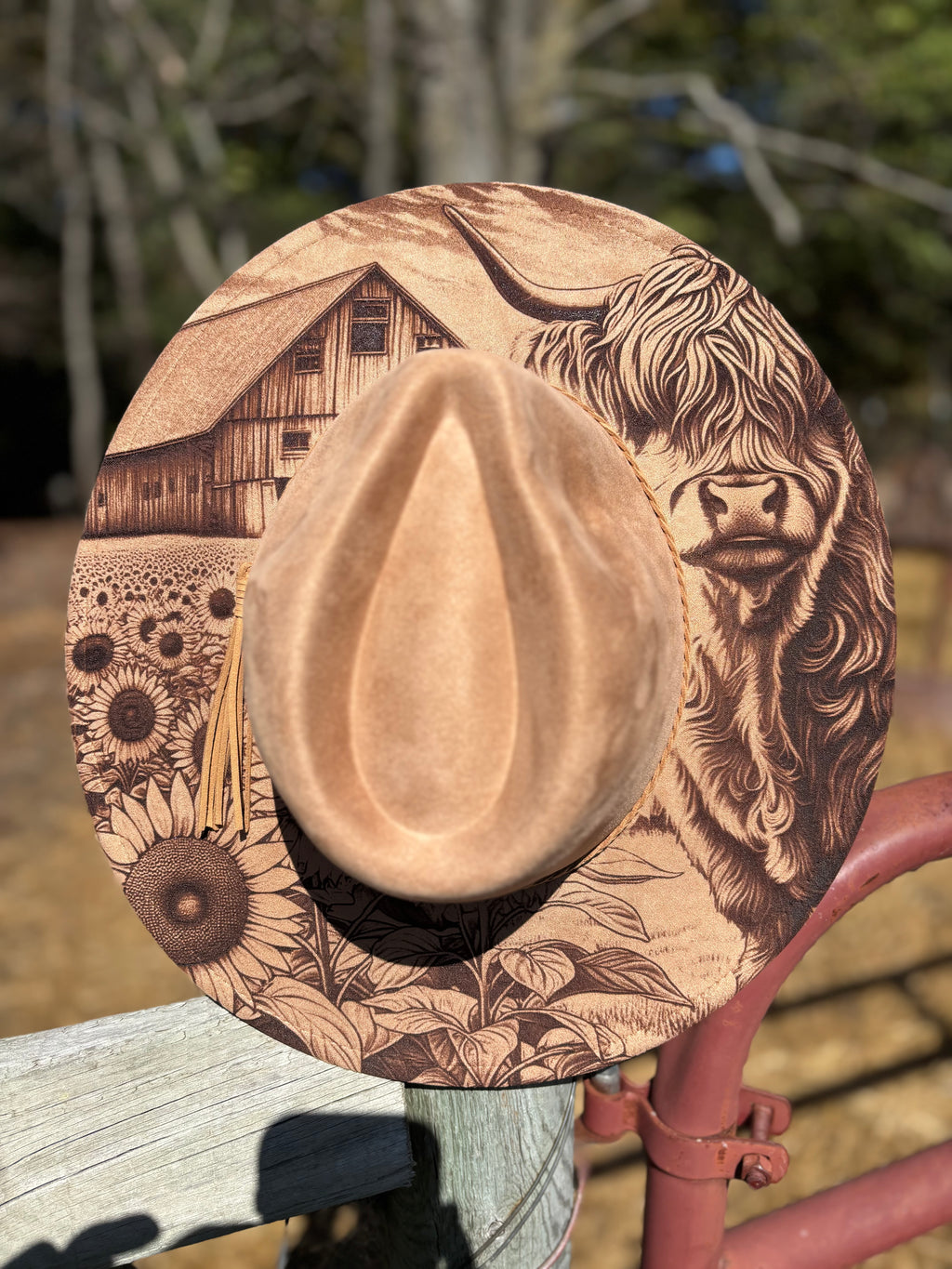 Tan suede hat with engraved lion face and rustic floral and barn scene