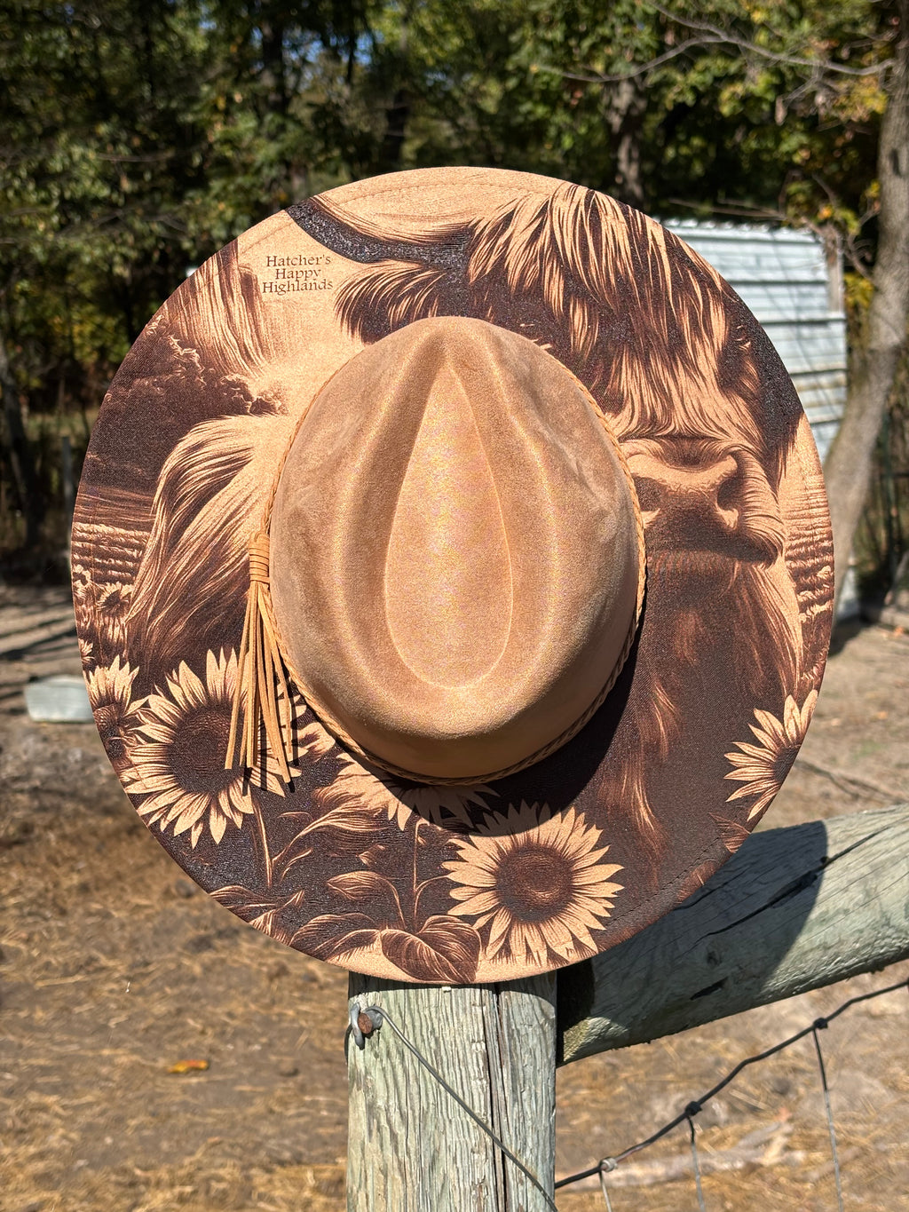 Brown suede hat with engraved lion face and sunflower field, wide brim