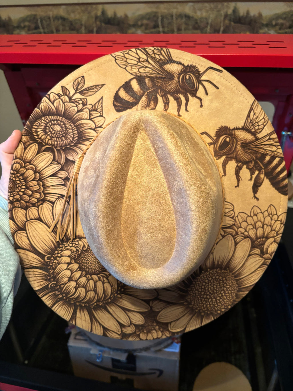 Engraved suede fedora hat in tan with engraved bee and flower artwork around the brim