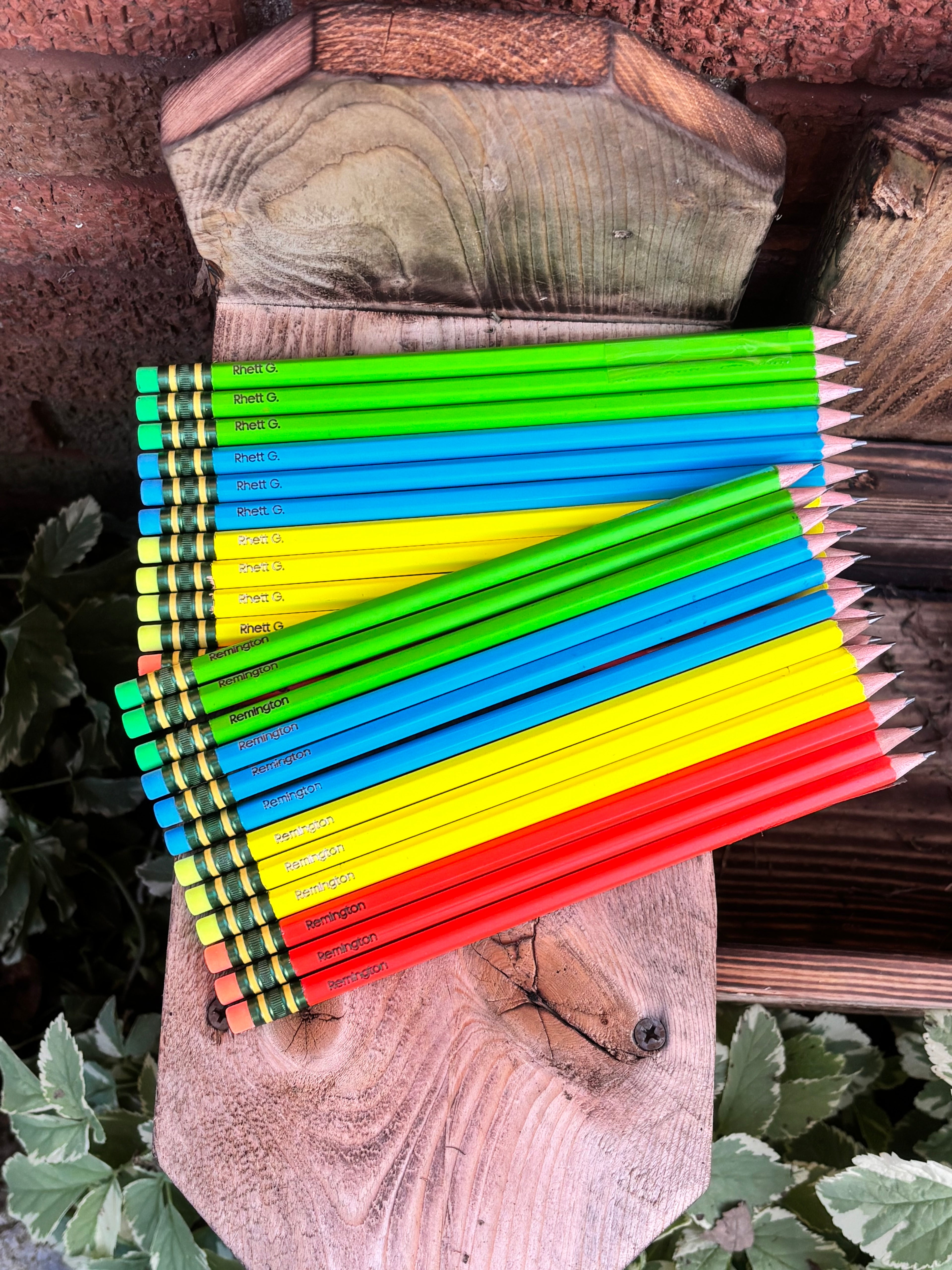 Neon colored pencils, bright green, blue, yellow, and red barrels with printed text