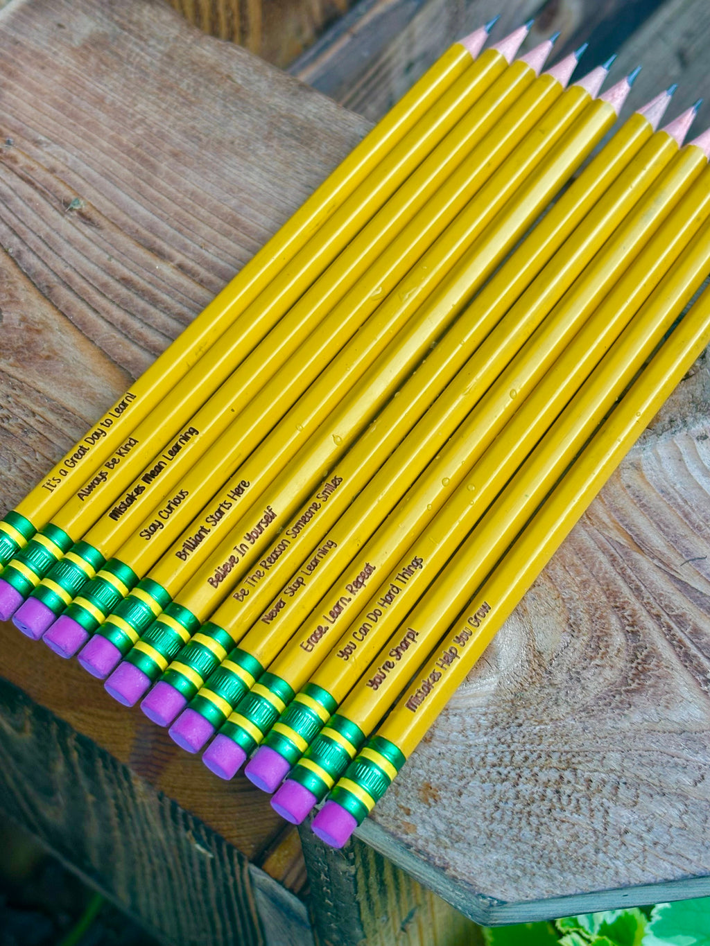 Yellow colored pencils with purple and green end caps, printed labels on barrels