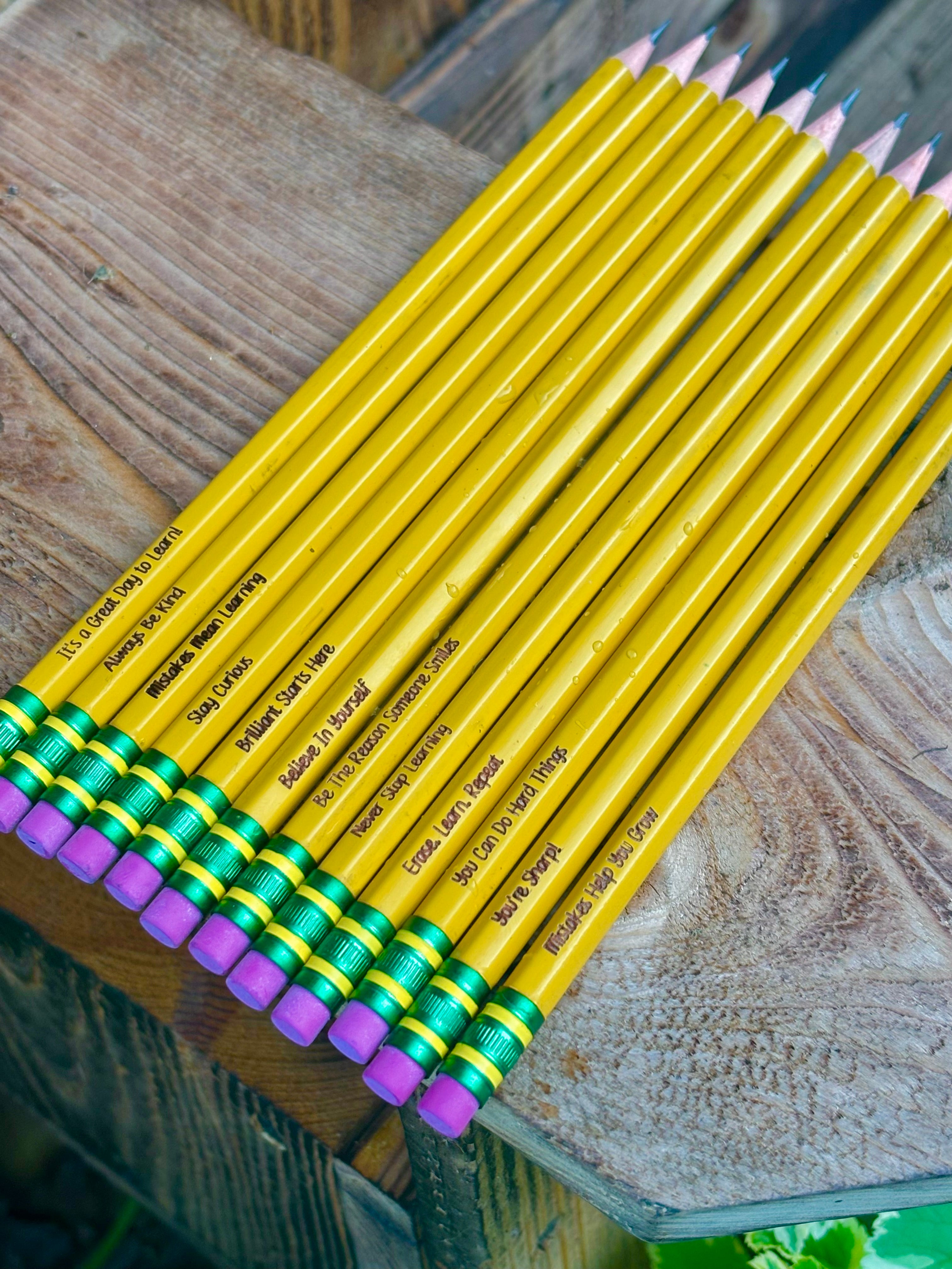 Yellow colored pencils with purple and green end caps, printed labels on barrels