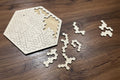 Light wooden hexagon jigsaw puzzle with interlocking pieces laid out
